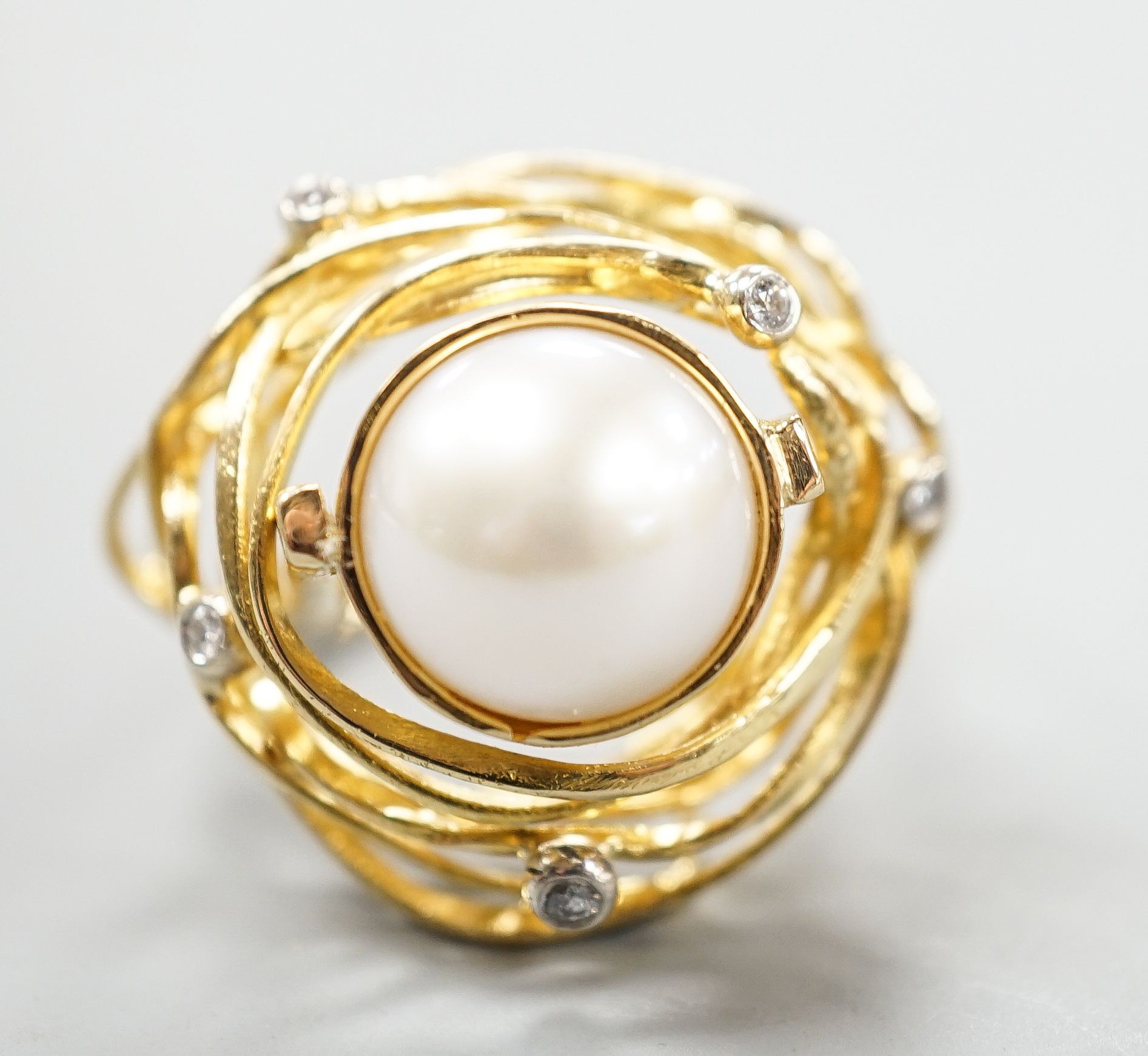 A modern 750 yellow metal, mabe pearl and diamond chip set modernist dress ring, size Q, gross 13.2 grams.